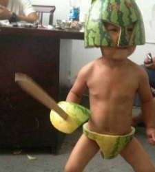 Menino vestido de guerreiro com uma melancia